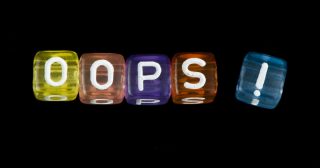 Word Oops. Black isolated cubes. Studio shot